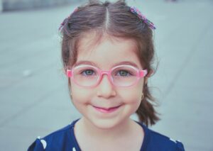bambina con occhiali rosa
